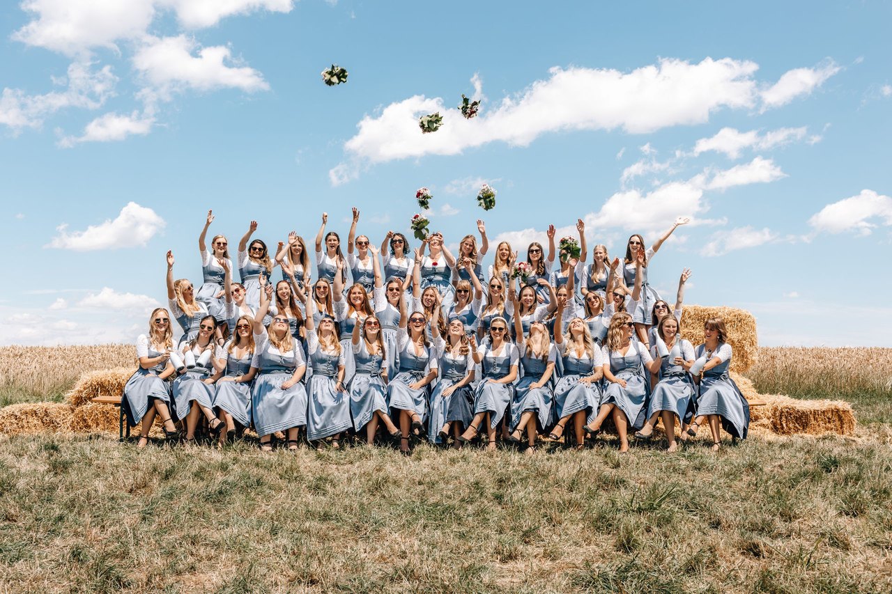Festdamen werfen ihre Blumensträuße in die Luft
