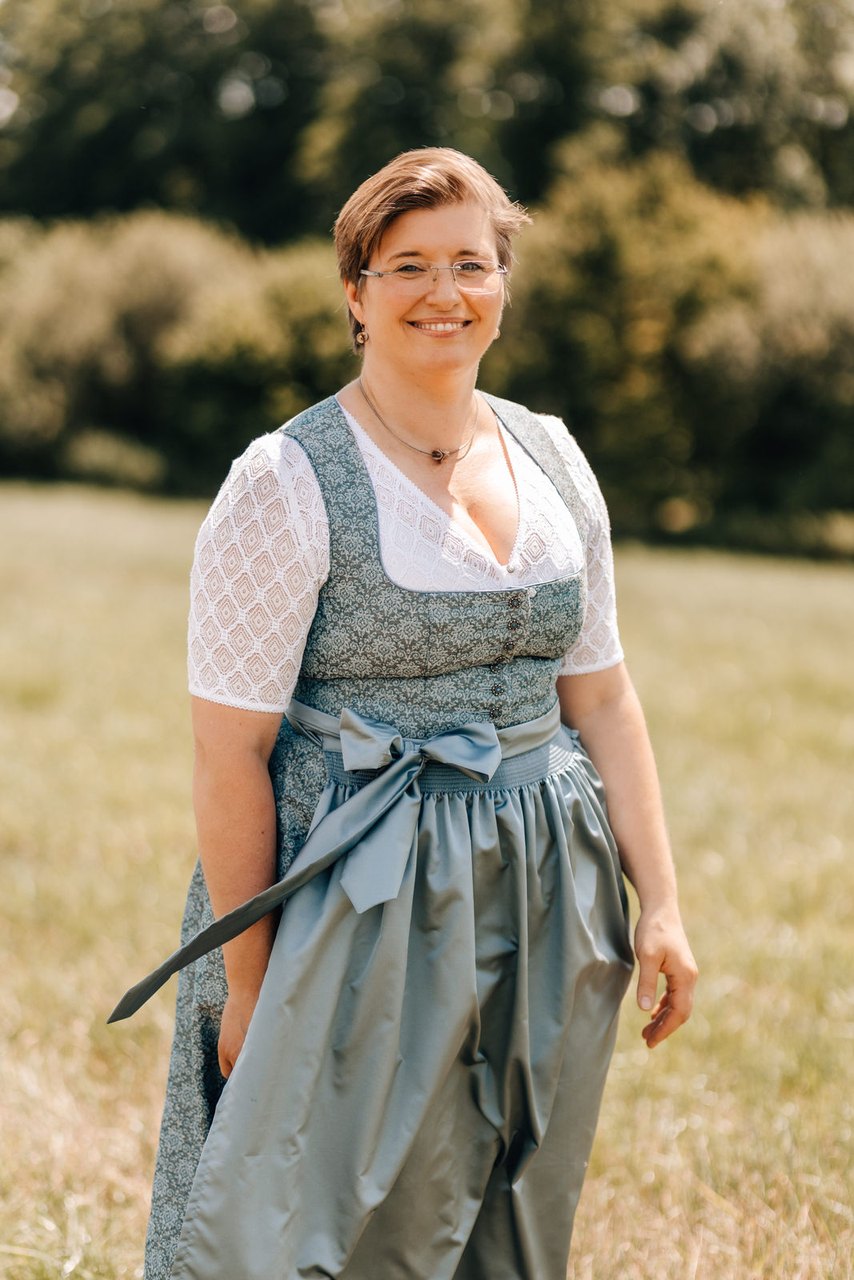 Fahnenmutter Sandra Schumertl im Dirndl auf einer Wiese