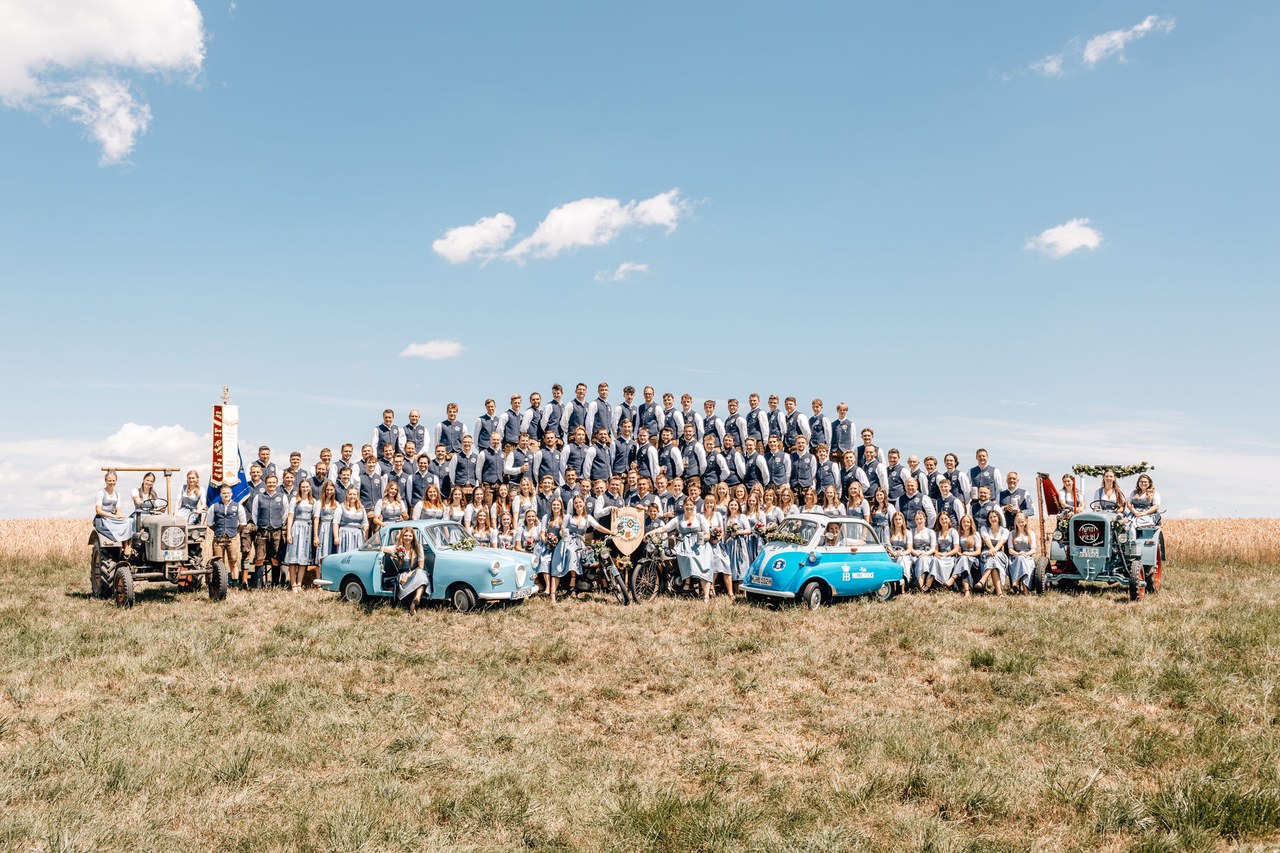 Der Verein mit Traktor, Oldtimern und Motorrädern auf dem Feld